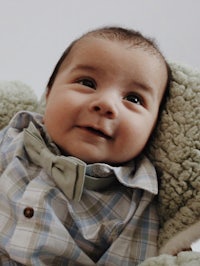 a baby wearing a plaid shirt and a bow tie