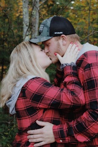 a couple kissing in the woods