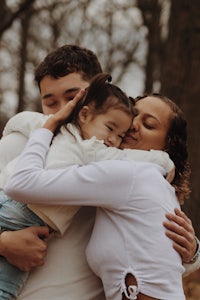 a family hugging in the woods