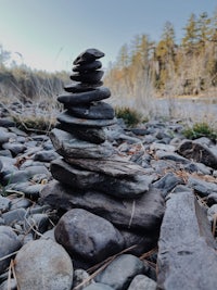 a stack of rocks next to a river