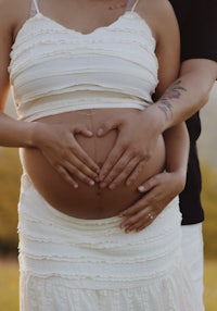 a pregnant couple holding hands in a field