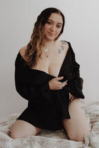 a woman with tattoos posing on a bed