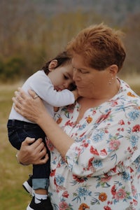 a woman holding a child in a field