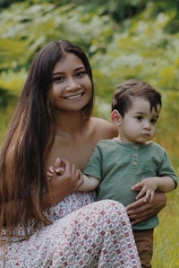 a woman holding a child in a field