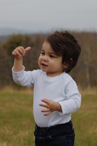 a child is standing in a field with a frisbee