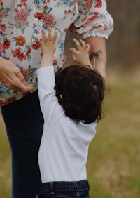 a woman holding a child in a field