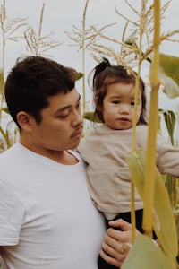 a man and a child standing in a corn field