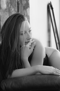 a black and white photo of a woman laying on a couch