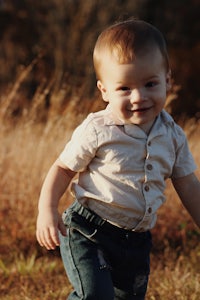 a young boy is running in a field