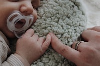 a baby is laying on a blanket with a pacifier