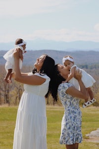 a mother and her two daughters are holding their babies in the air