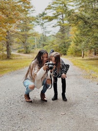 a mother and daughter taking a picture with a camera