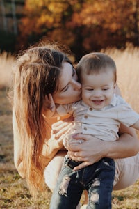 a woman kissing her son in a field