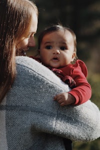 a woman is holding a baby in her arms