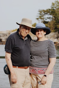 a man and a woman standing next to a body of water