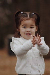 a little girl is waving a frisbee in the air