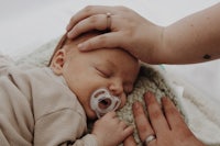 a woman is holding a baby's pacifier