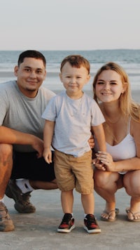 a family posing for a photo on the beach