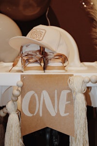 a baby's first birthday party with a hat and shoes on a table