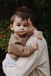 a man is holding a baby in his arms