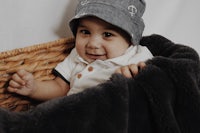 a baby wearing a hat in a basket