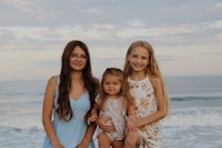 three girls pose for a photo on the beach