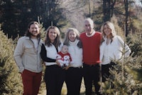 a family posing for a photo in a christmas tree farm