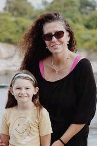 a woman in sunglasses and a young girl posing for a picture