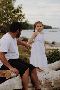 a man and a little girl sitting on a log