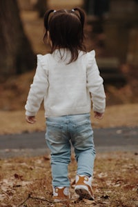 a little girl walking through a park