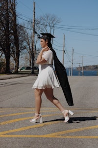 a woman in a white dress crossing the street