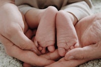 a pair of hands holding a baby's feet